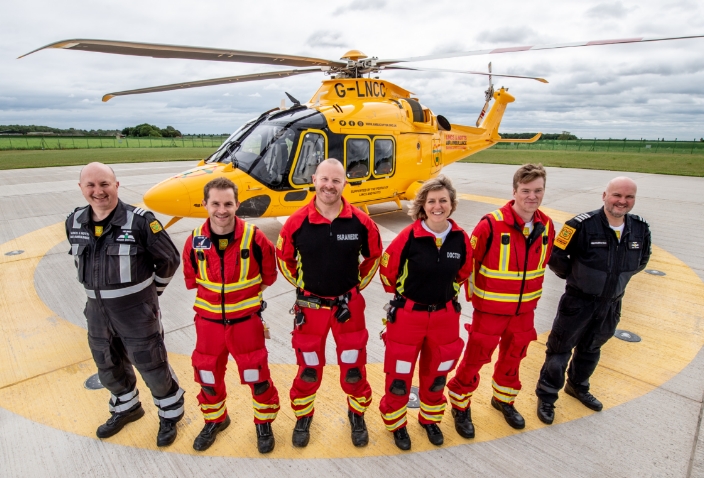 Crew standing in front of helicopter