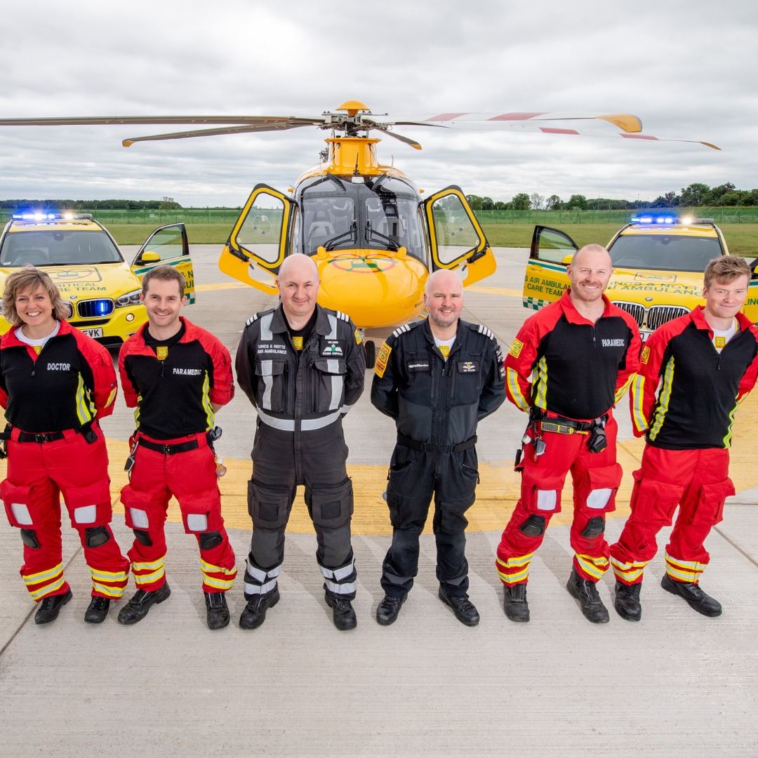 Crew in front of helicopter and critical care cars