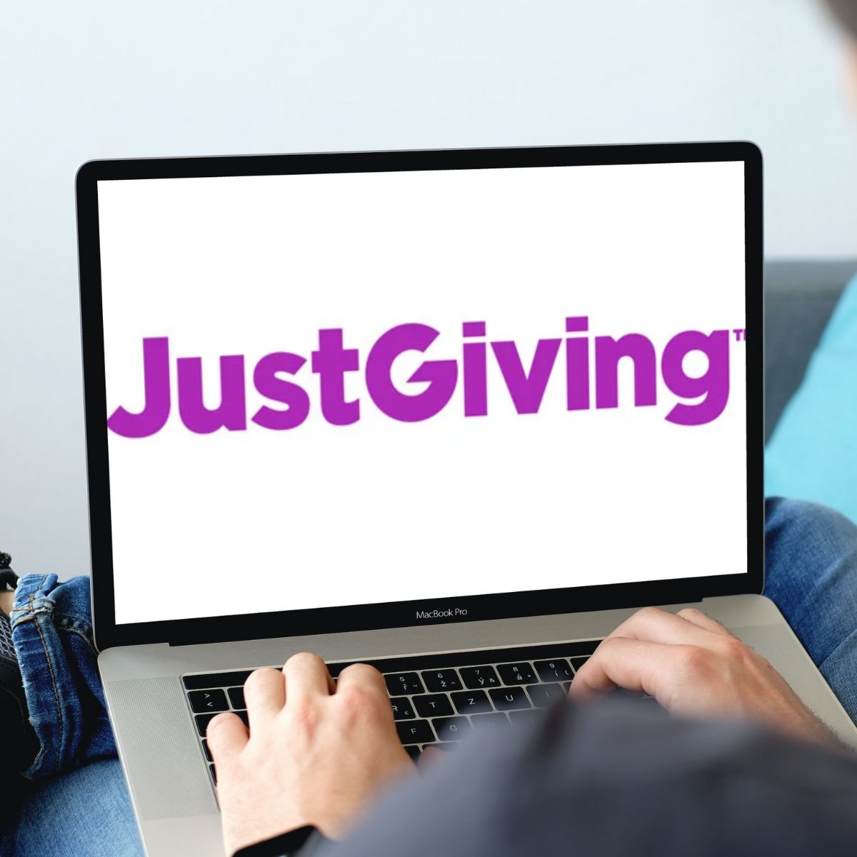 Man on his laptop with JustGiving logo