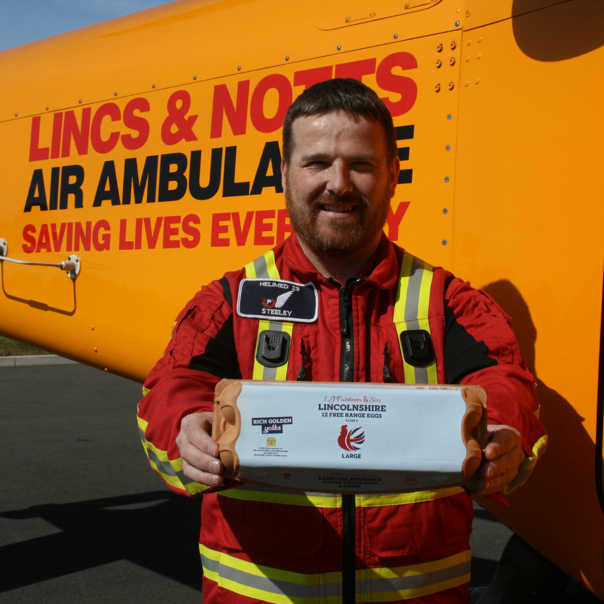 Paramedic holding a Fairburn eggs carton. One of our business partnerships.