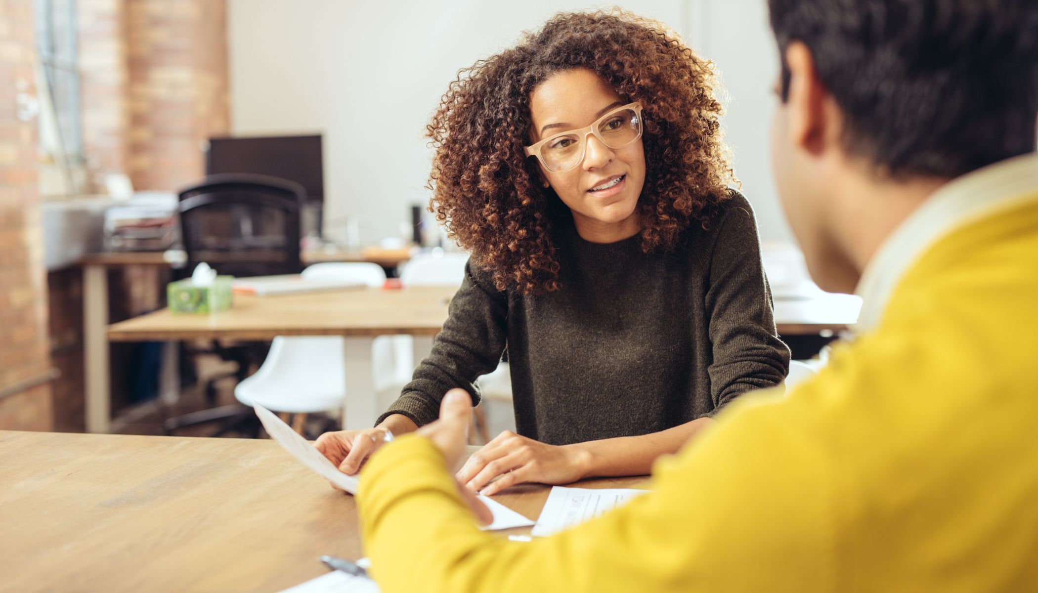 Two people speaking at a desk