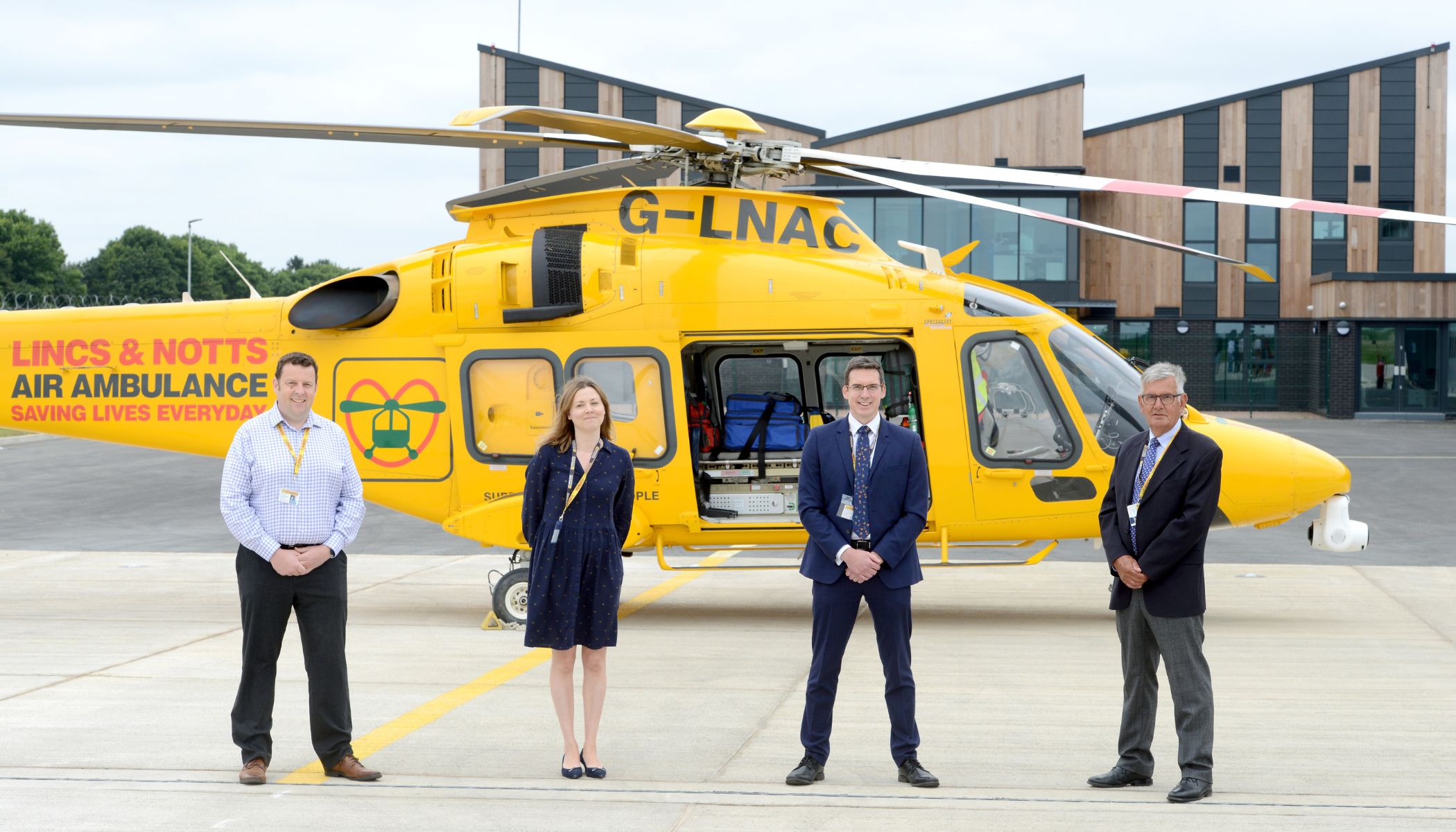 Trustees in front of helicopter