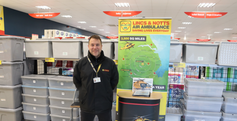 Canvasser in shop with fundraising stand
