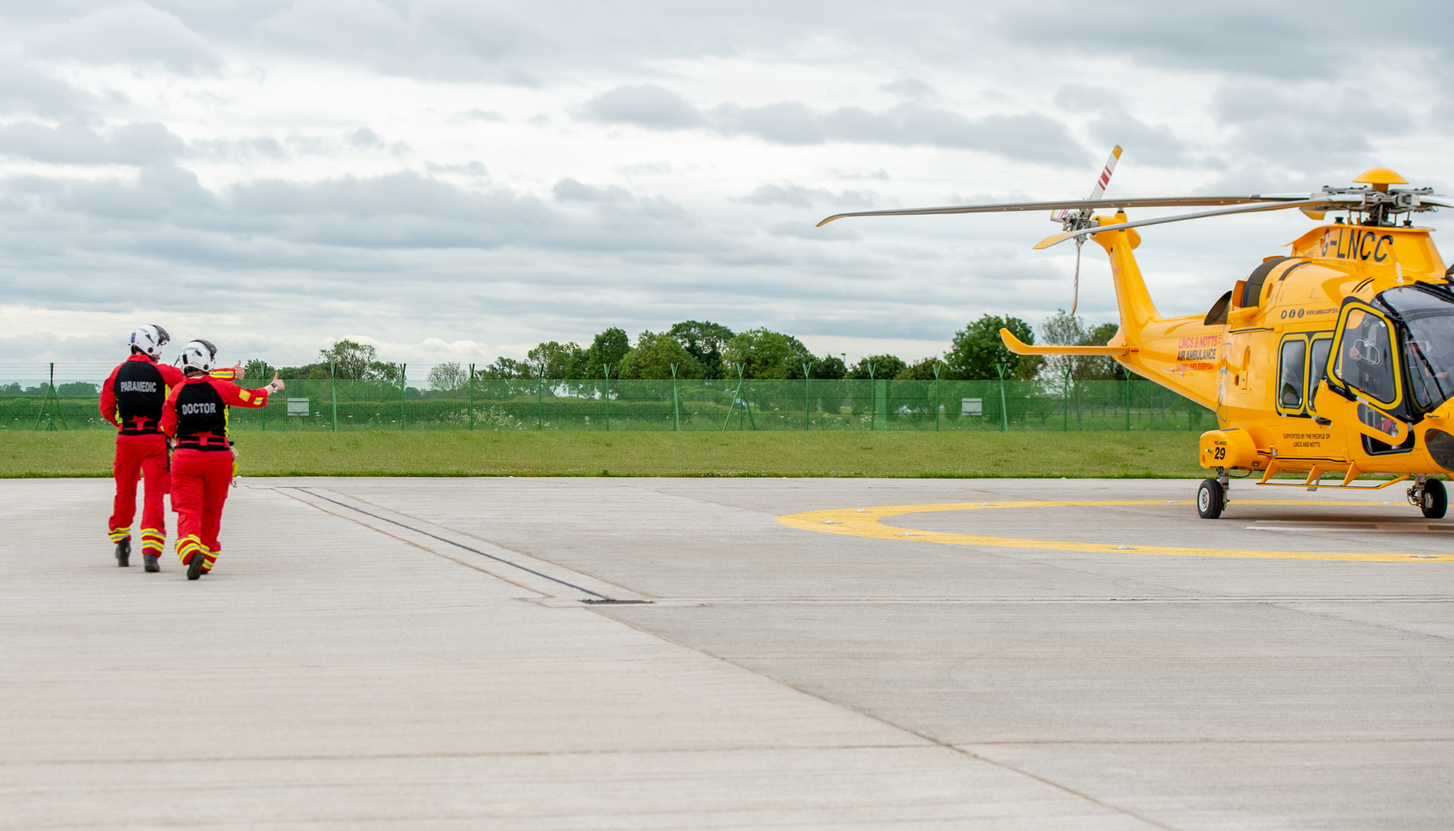 Docotor and paramedic approaching helicopter for take off