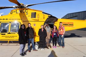 people standing next to LNAA helicopter