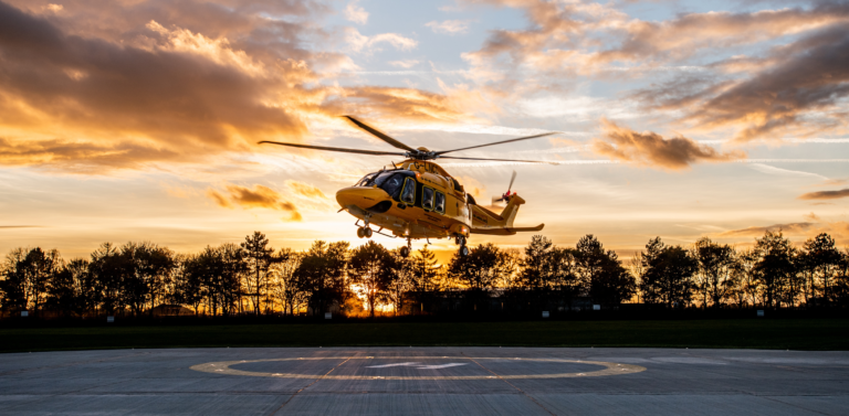 Helicopter taking off at sunset