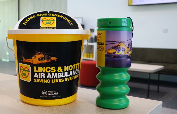 Collection bucket and tin sitting on a desk