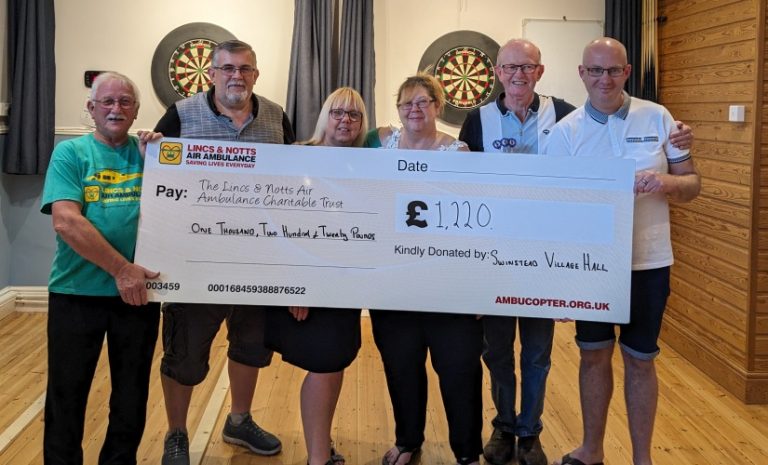 Swinstead village hall darts marathon present cheque to LNAA