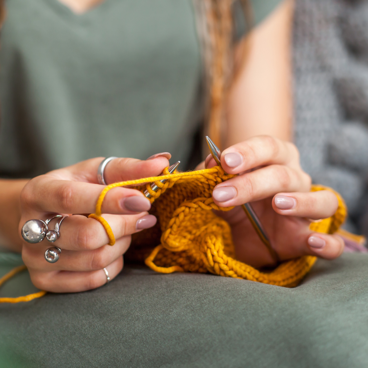 Women knitting yellow yarn