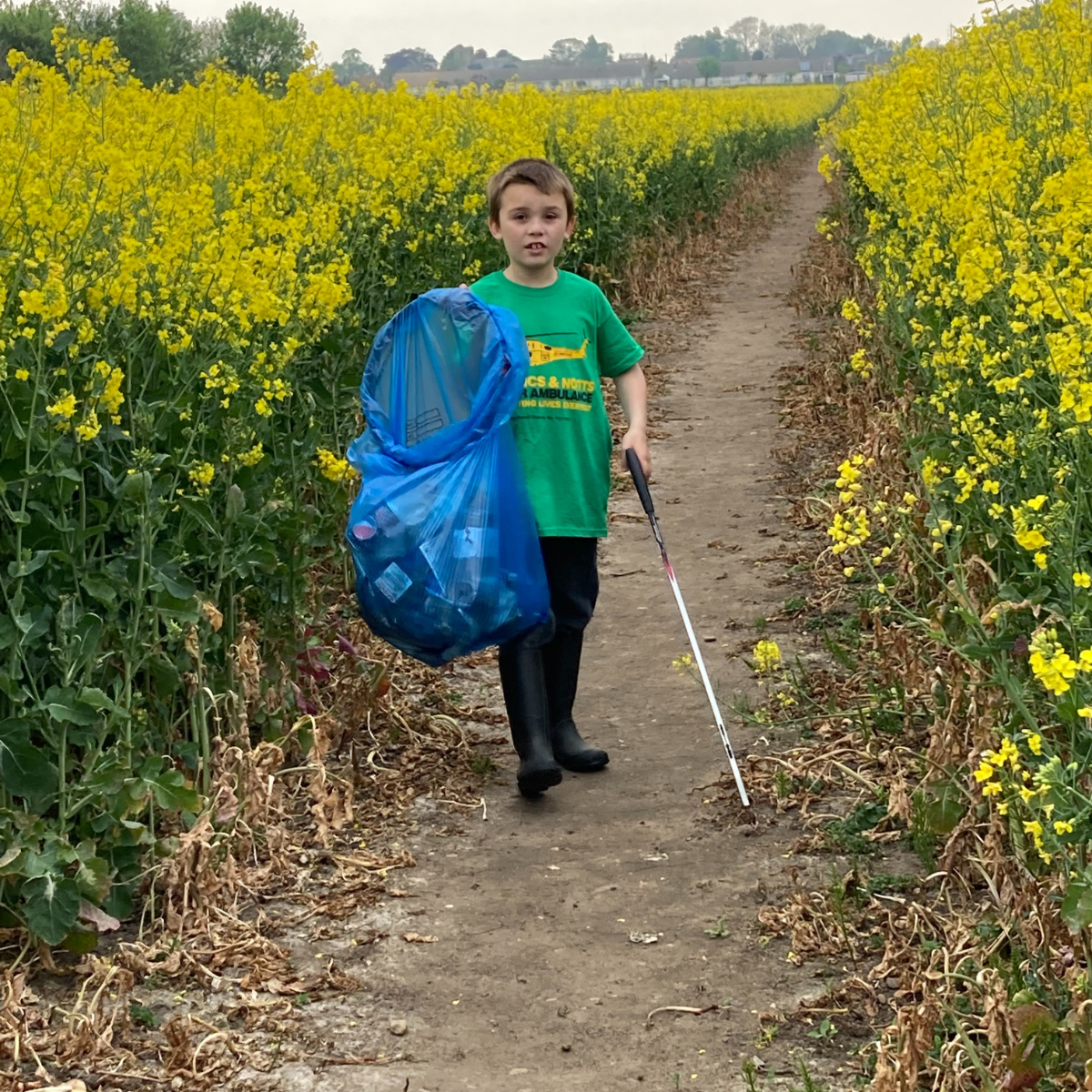 Boy picking up litter in LNAA t-shirt