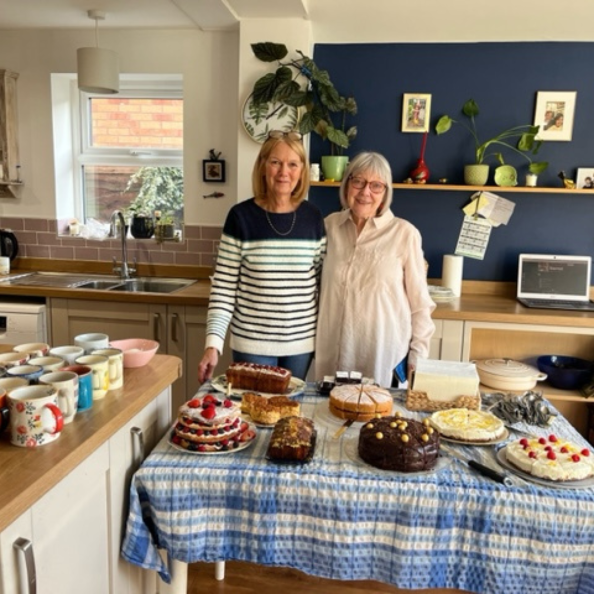 Two women standing in front of homemade cakes