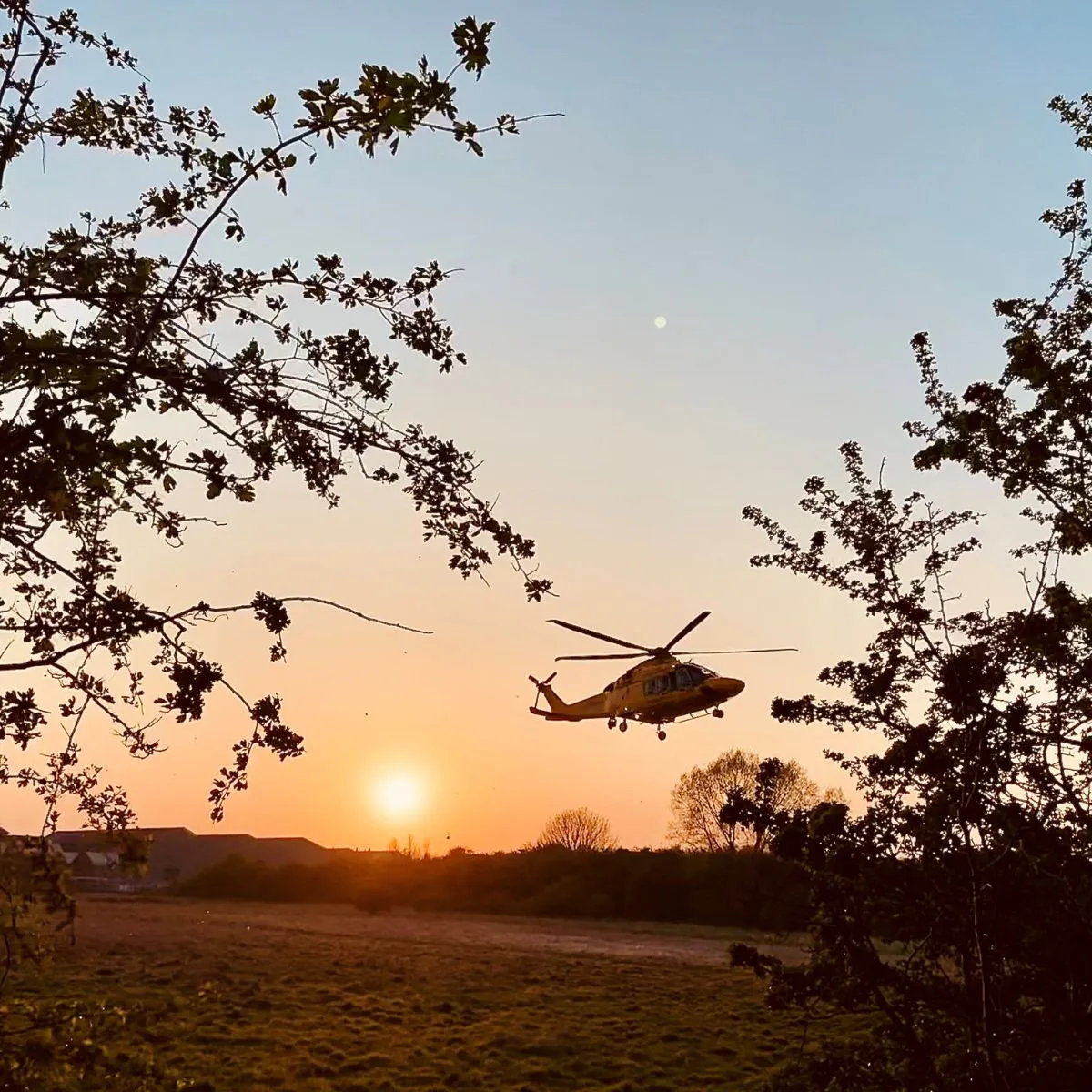 Helicopter taking off at sunset
